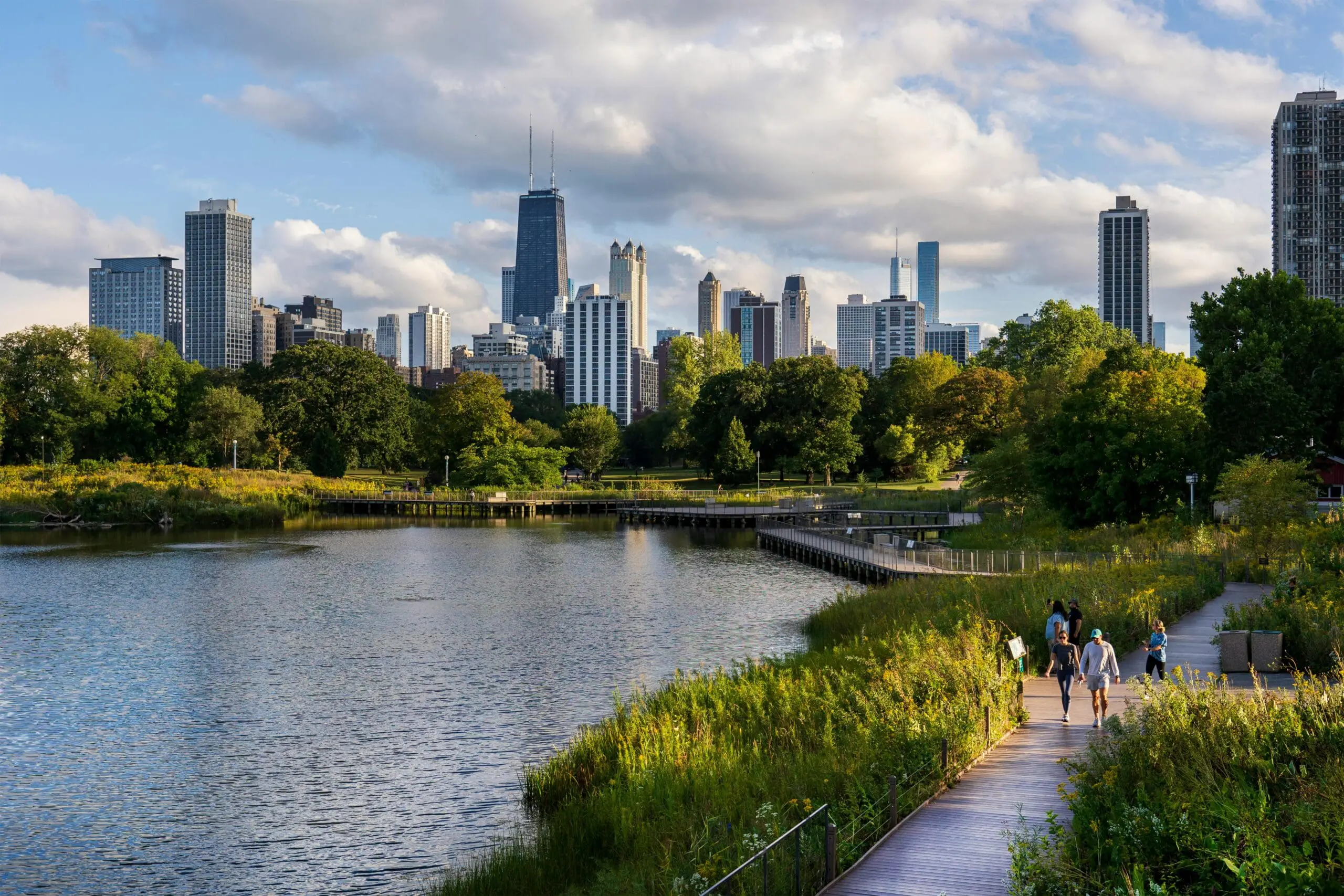 Pond Fountain Solutions - urban park pond with city skyline and boardwalk showing fountain aeration to improve water quality